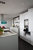 White kitchen with island counter and dark grey tiled floor