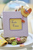 Hand-crafted picture frame with Easter greeting, straw wreath and ornaments