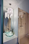Elegant bathroom with shower, tall mirror and pendant lamp with glittery fabric lampshade