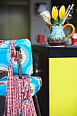 Red and white gingham fabric bag on 50s kitchen chair with twee doily pattern