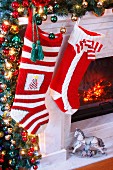 Knitted Christmas stockings hung on festively decorated mantelpiece