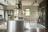 Kücheninsel mit Edelstahlfront unter Abzugshaube in Designerküche mit Einbauschränken