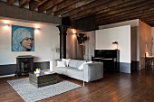 Antique stove below large Renaissance portrait in lounge area of loft apartment with rustic wood-beamed ceiling