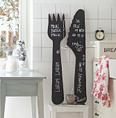 Huge, hand-crafted ornamental cutlery painted with blackboard paint used as note board in country-house kitchen