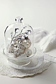 Silver Christmas decorations under glass cover