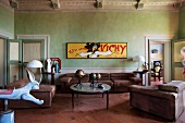 Yellow, vintage advertising sign on wall painted lime green and sofa set in Italian, Renaissance period apartment