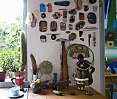Eine Sammlung bemalter Steine und Treibhölzer an der Wand über Küchenarbeitsplatte mit kunsthandwerklicher Deko