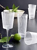 Wine and water glasses with etched pattern and limes on black tabletop