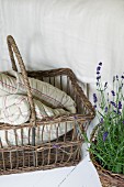 Geflochtener Korb mit Decke und blühender Lavendel im Topf