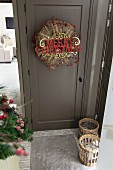 Haustür dunkelgrau lackiert mit aufghängtem Weihnachtsschmuck und Weihnachtsgruss