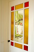 Vintage interior door with stained glass panels and view into kitchen