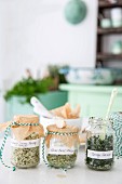 Three different home-made herb salts in storage jars