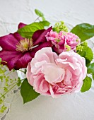 Pink peony and clematis flowers in vase