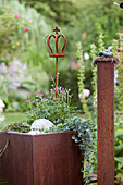 Planter with ornamental crown and pillar made from rusty metal