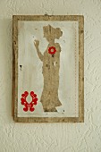 Silhouette-style artwork with red motifs on old wooden board