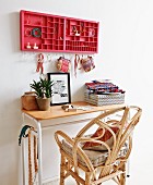 Rattan chair at small table below red type case holding jewellery and small, Oriental bags