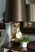 Table lamp with sculptural brass base and dark brown lampshade