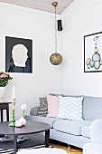 Black round coffee table, grey sofa and pendant lamp with spherical metal lampshade