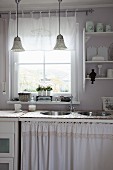 Sink unit with two round basins and curtain below window in shabby-chic kitchen