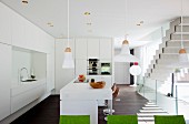 Free-standing counter in open-plan white designer kitchen