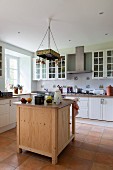 Free-standing wooden counter in country-house kitchen with terracotta-tiled floor