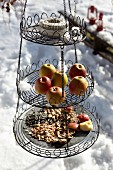 Bird feeding station on three levels: wire cake stand filled with bird food
