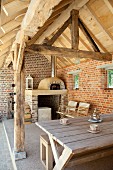 Rustic roofed terrace with exposed masonry and pizza oven on renovated farm