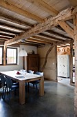 Offener moderner Essbereich in renoviertem Bauernhaus mit rustikaler Holzkonstruktion und poliertem Betonboden