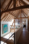 Blick von Galerieebene auf Dachkonstruktion und offenen Schlafbereich in modernisiertem Bauernhaus