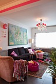 Simple living room with comfortable seating and chandelier with small, red lampshades