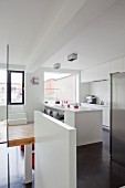 Moderne, weiße Kücheninsel in offenem Küchenbereich