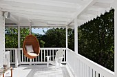 Classic Scandinavian design: wicker hanging chair by Nanna Ditzel on white veranda