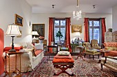 Interior filled with antique seating and side tables with mixture of patterns on Oriental rugs and traditional upholstery fabrics