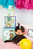 Soft toy next to stacked picture blocks of different sizes