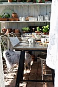 White metal chairs, fur rug and breakfast table in greenhouse