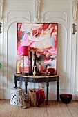 Collection of vases and abstract artwork on vintage console table