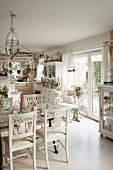 White-painted flea-market furniture in open-plan, cluttered, shabby-chic kitchen-dining room