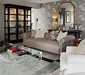 Classic living room in shades of grey with plexiglas coffee table and black display cabinet