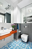 Grey walls in monochrome bathroom combined with wooden washstand and Oriental blue tiled floor