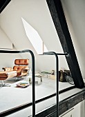 Designer Relax-Sessel und Fusshocker in Galeriebereich mit Gaubenfenster und Stahlleiter