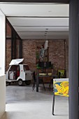 Dining area and bubble car against brick wall in loft apartment