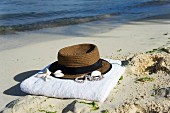 Hat and towel on sandy beach