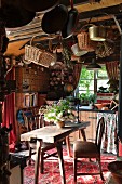 Baskets and pans hanging from ceiling above rustic dining table and chairs