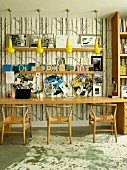Long table and classic wooden chairs against study wallpaper with pattern of tree trunks