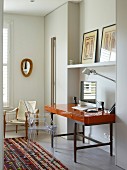 Ghost chair at desk with glossy top and metal frame in niche