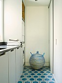 Spherical laundry basket with lid on patterned tiled floor of utility room