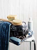 Towels in shades of blue, soaps and body brushes on spa stool