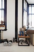 Exercise equipment on floor and side table with wooden top on black metal frame