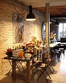 Vintage pendant lamps above groceries on table in rustic interior with exposed brick wall