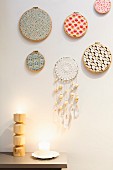 Embroidery frames covered in colourful fabrics and hand-crafted dreamcatcher hung on wall